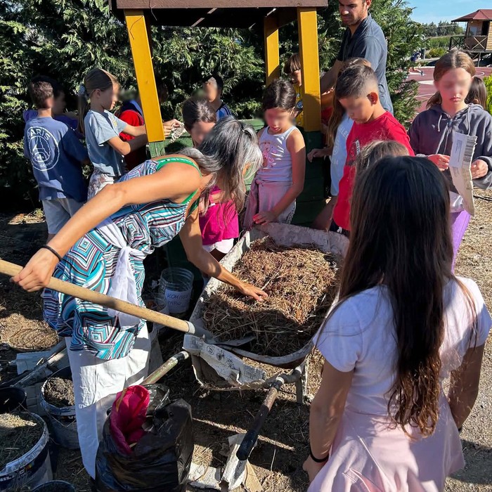 Des enfants coopèrent avec une brouette et des matières organiques